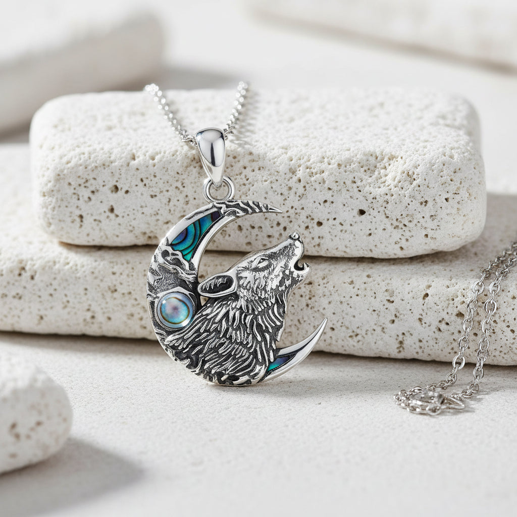 Silver necklace with wolf and moon design on a white background