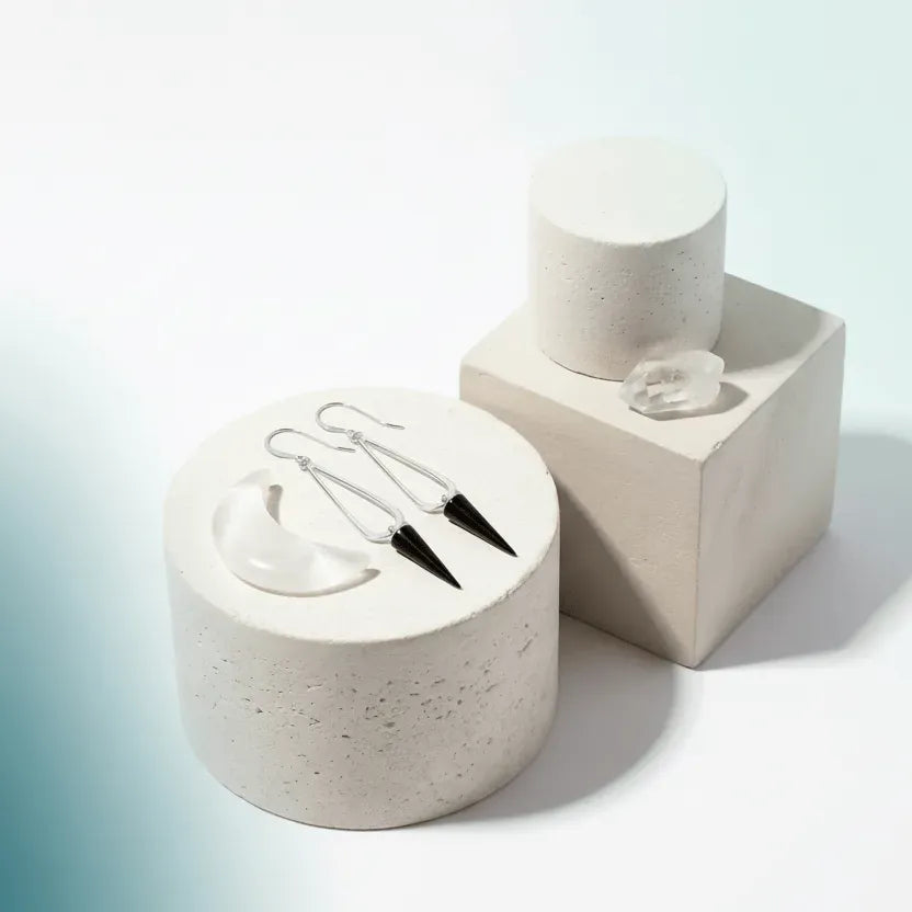 Stiletto dangle earrings on a stone surface with 'Mystic Soul Jewelry' branding.