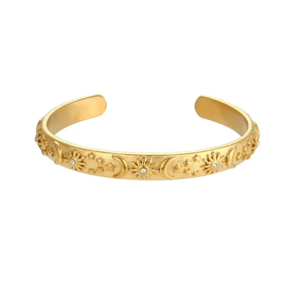 Gold bracelet with intricate designs on a white background