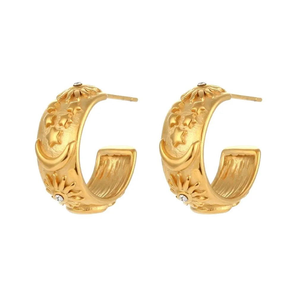 Gold hoop earrings with intricate designs on a white background
