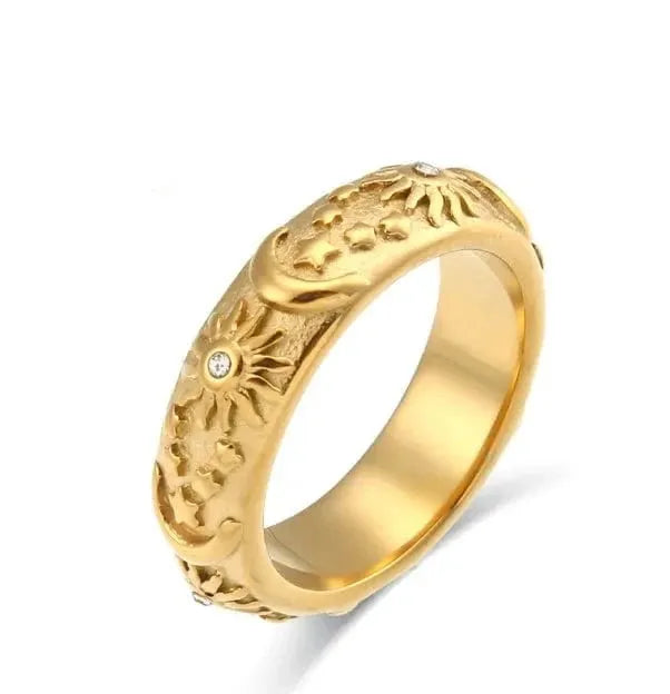 Gold ring with intricate design on a white background