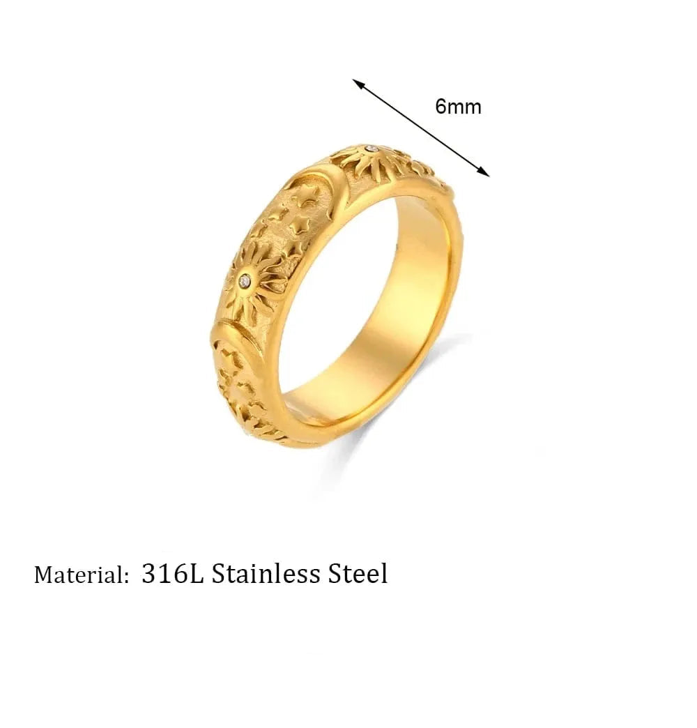 Gold ring with engraved design on a white background