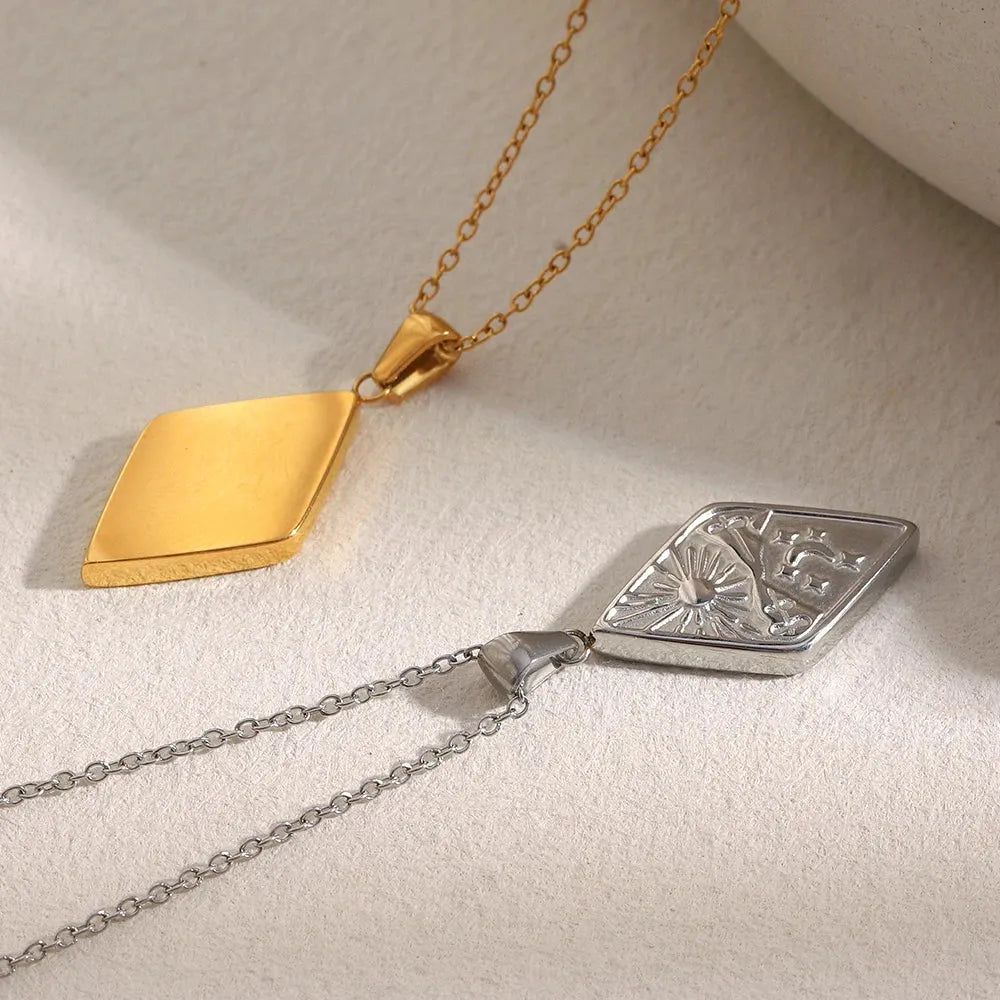 Gold and silver pendants on chains against a light background