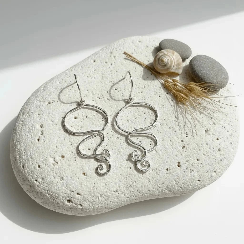 Silver earrings on a white stone with natural elements