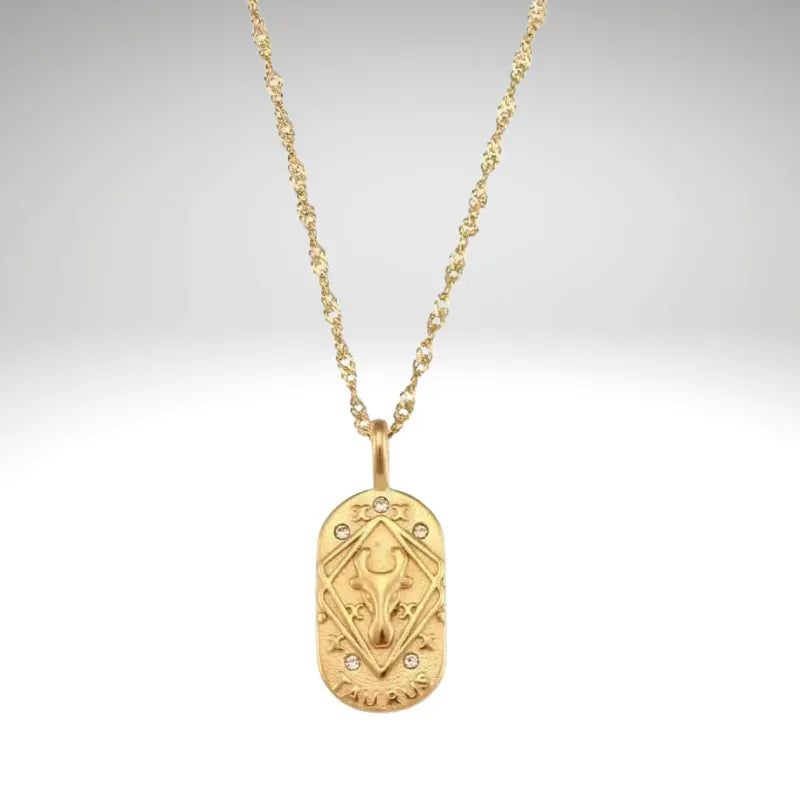 Gold necklace with a pendant on a light gray background