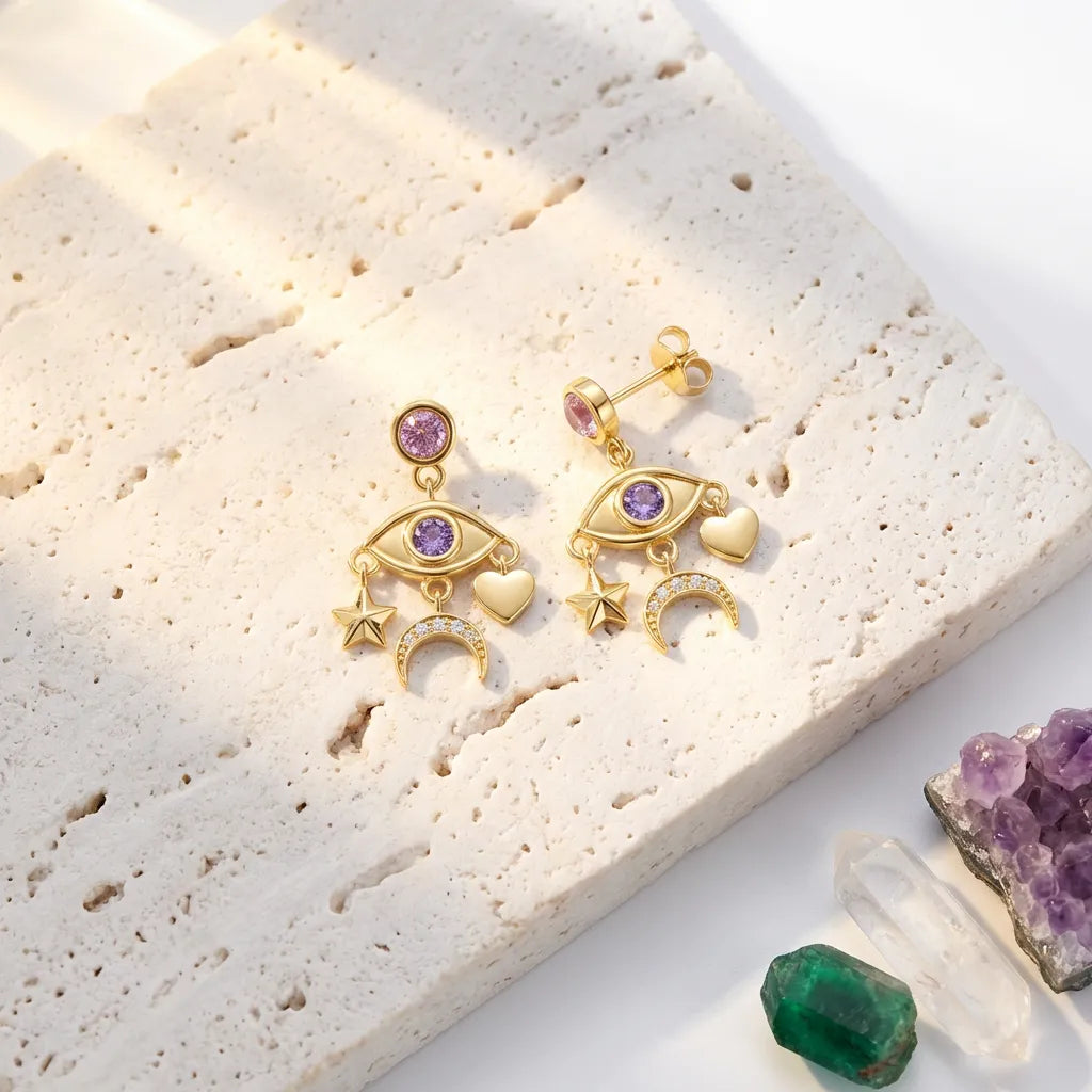 Gold earrings with gemstones on a textured surface