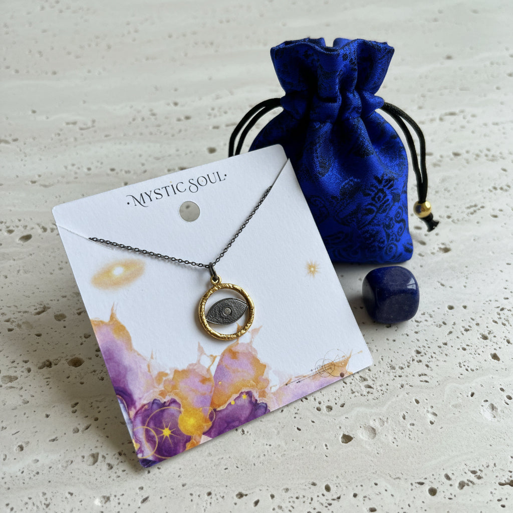 Gold and gunmetal evil eye necklace on a Mystic Soul gift card with a blue silk pouch