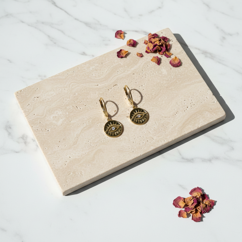 Third eye mini medallion earrings with crystal eye, flat lay in gold — jewelry for intuition