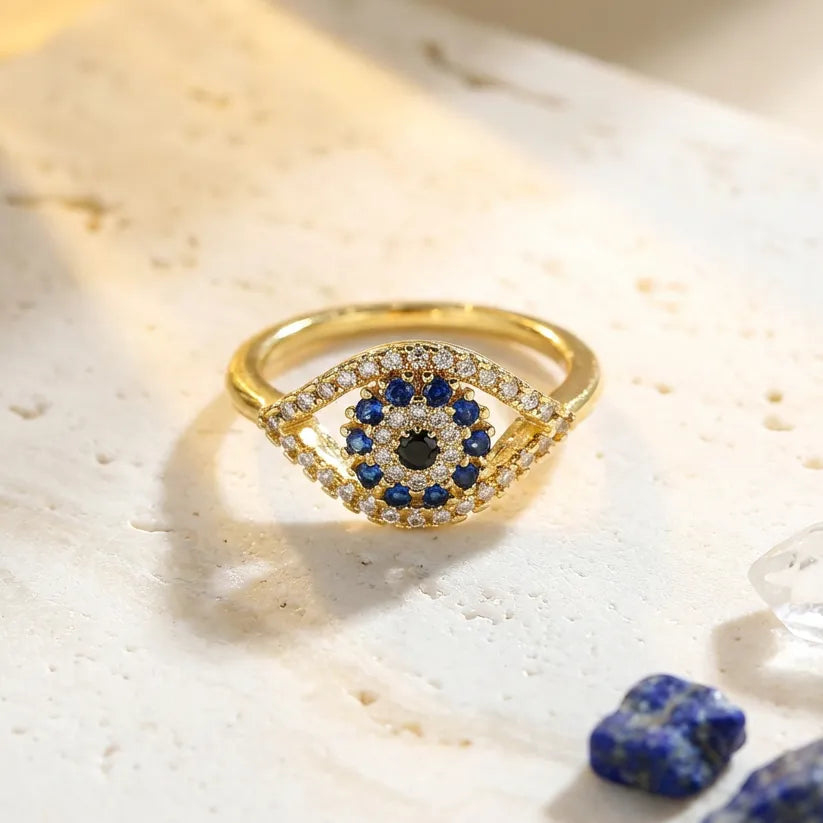 Gold ring with blue gemstones on a textured surface