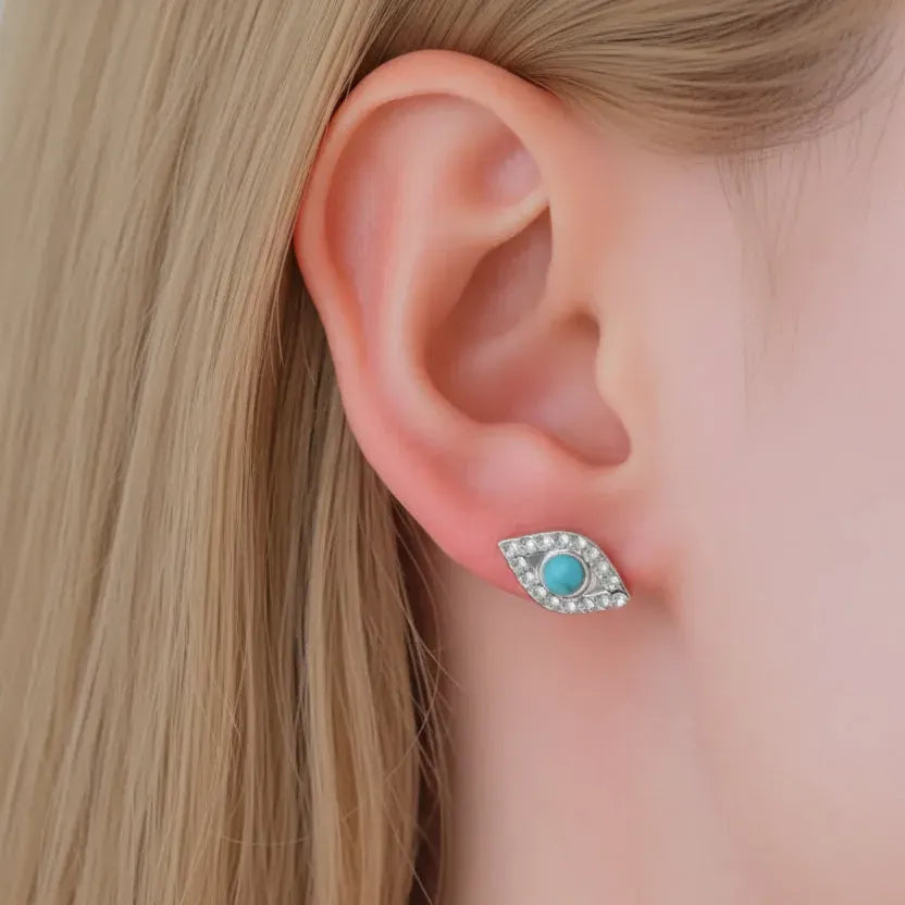 Woman wearing turquoise evil eye stud earring in silver, spiritual symbol jewelry