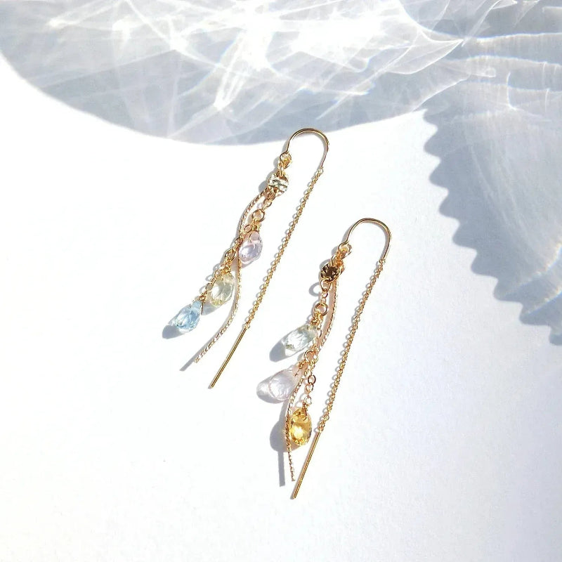 Gold earrings with gemstones on a white surface