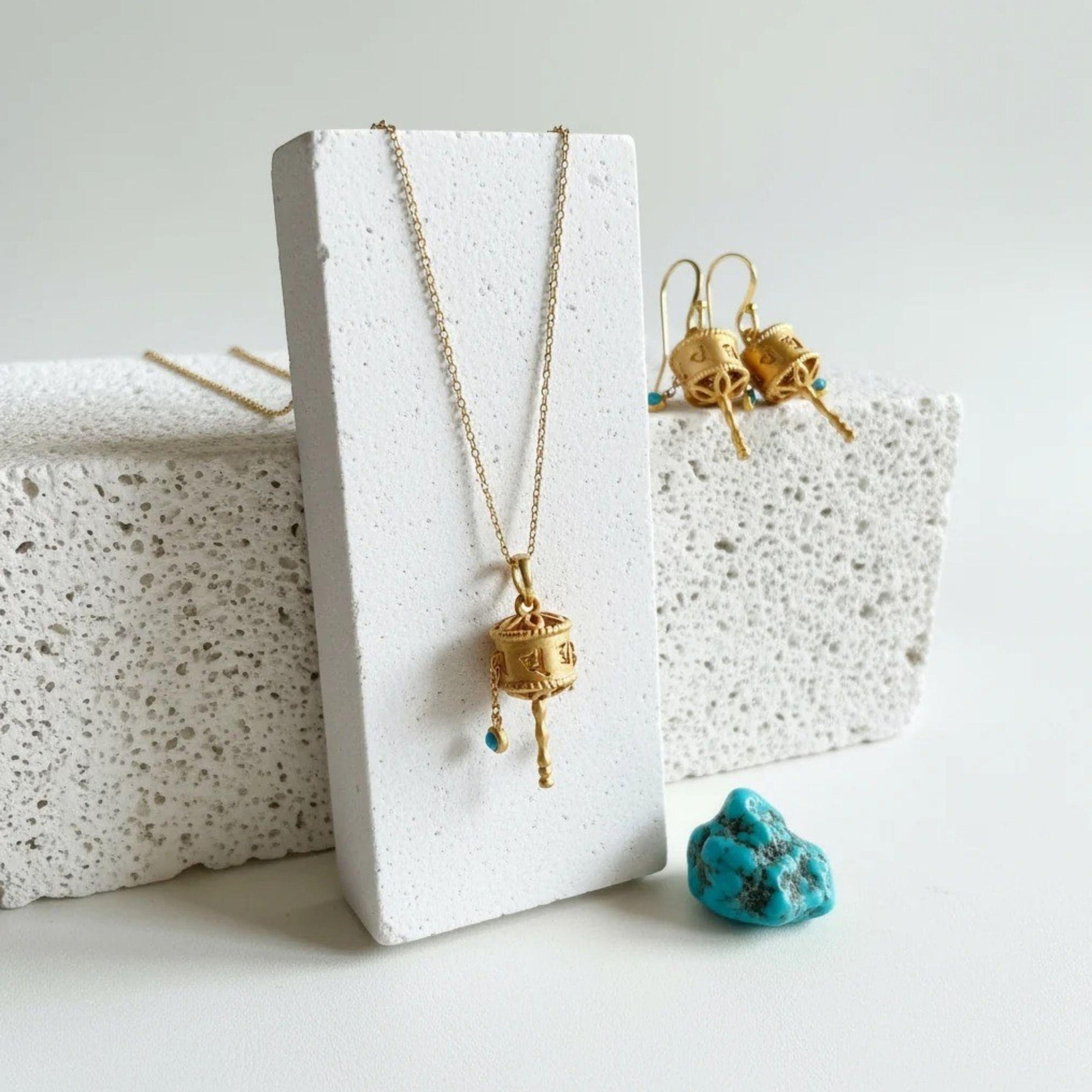 Tibetan prayer wheel necklace and matching drop earrings in sterling silver with 22k gold plating and a small turquoise-coloured resin accent