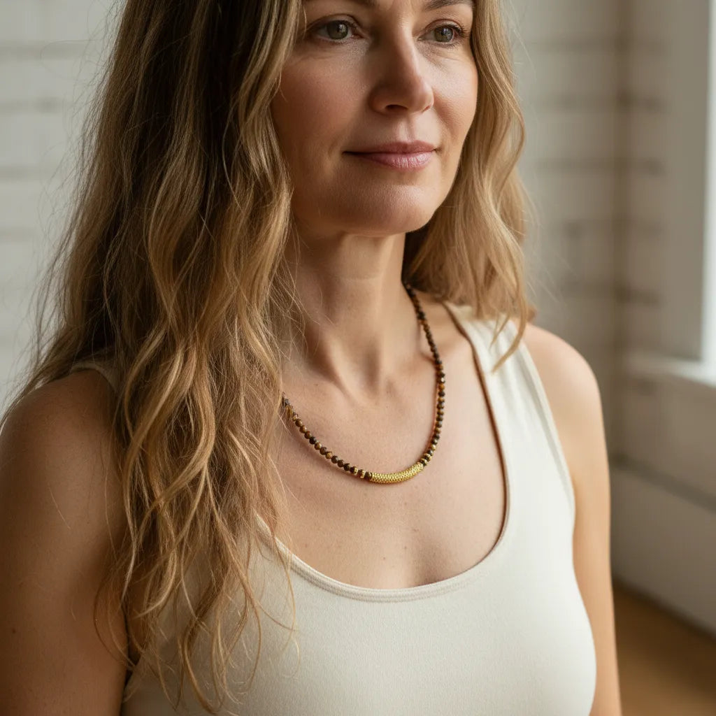 Woman wearing a white tank top and a necklace with a blurred background