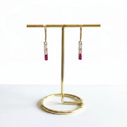 Close-up of gold plated pink tri-colour crystal bar earrings with clear baguette