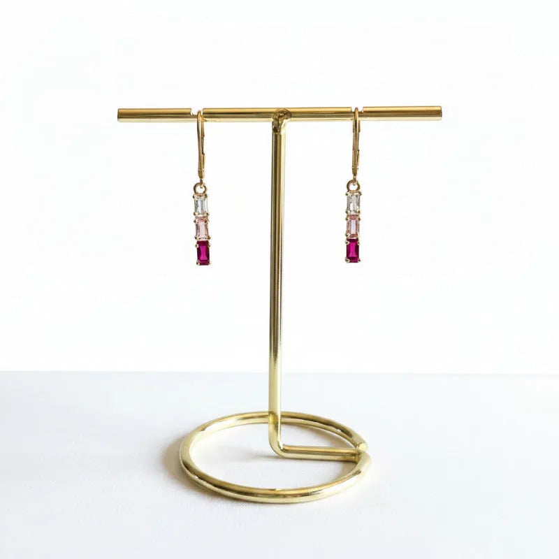 Close-up of gold plated pink tri-colour crystal bar earrings with clear baguette