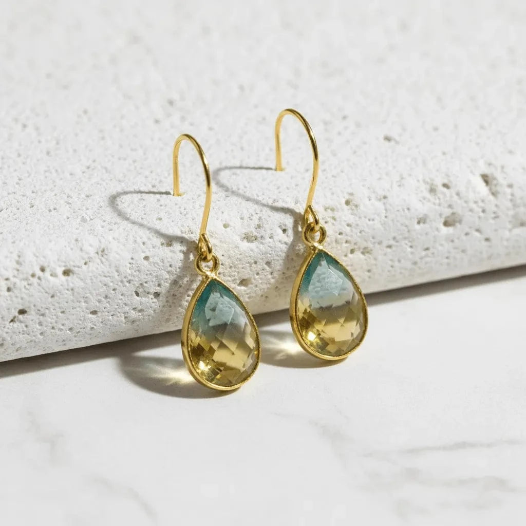 green yellow gold earrings on white stone background