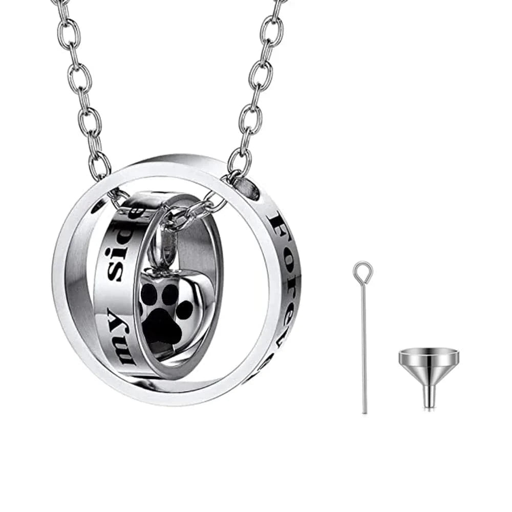 Silver necklace with paw print design and two small tools on a white background