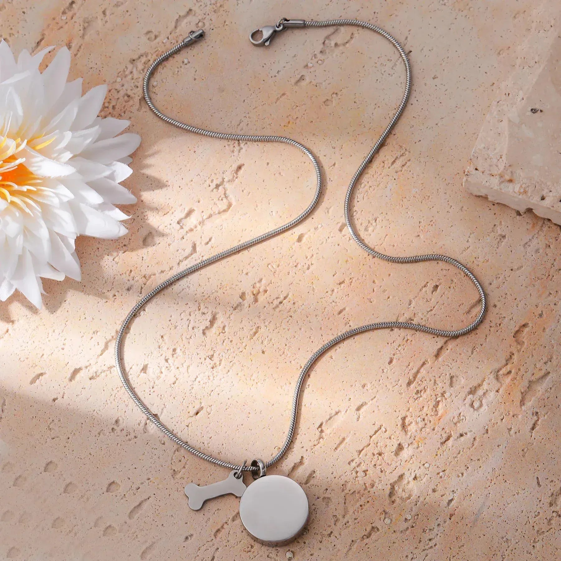 Necklace with a pendant on a textured surface with a flower