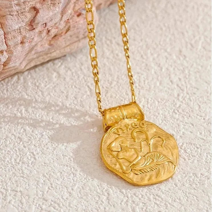 Gold necklace with a round pendant on a textured surface