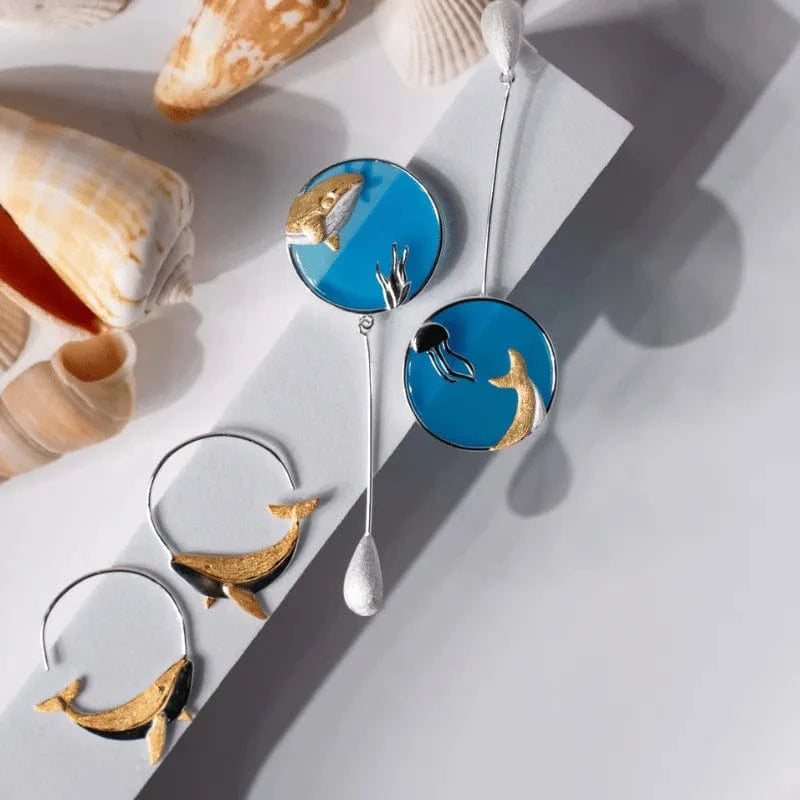 Decorative spoons with whale designs on a light gray background