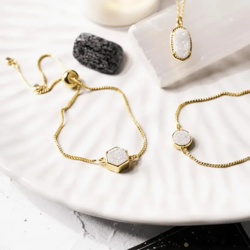 Gold bracelets with gemstone accents on a white surface