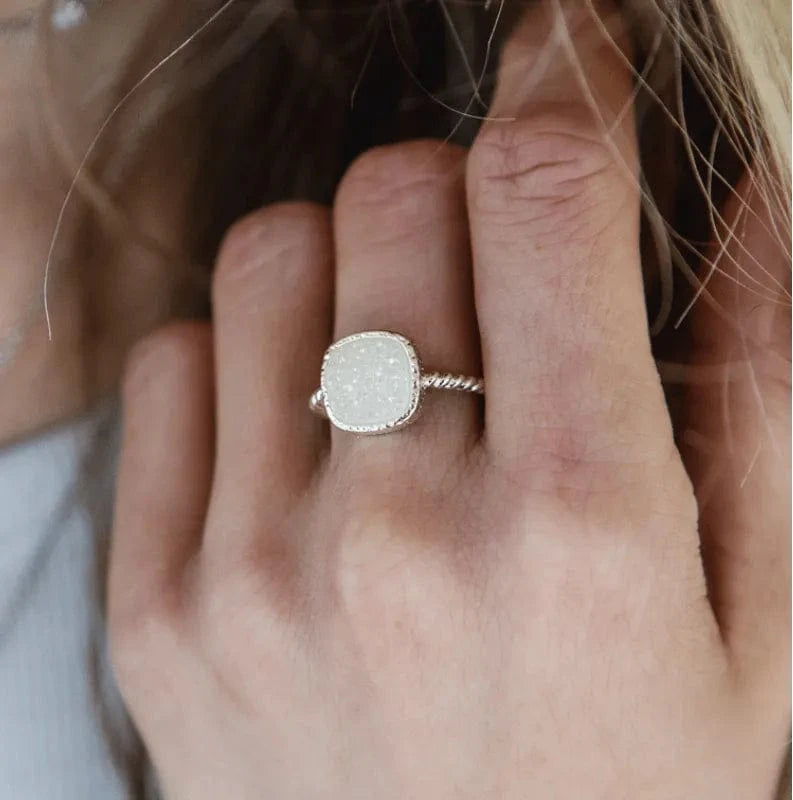 Close-up of a hand wearing a silver ring with a textured band.