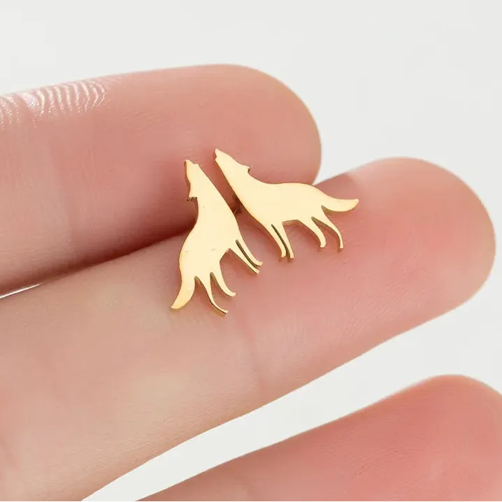 Gold wolf-shaped earrings on a finger with 'jisensp' branding.