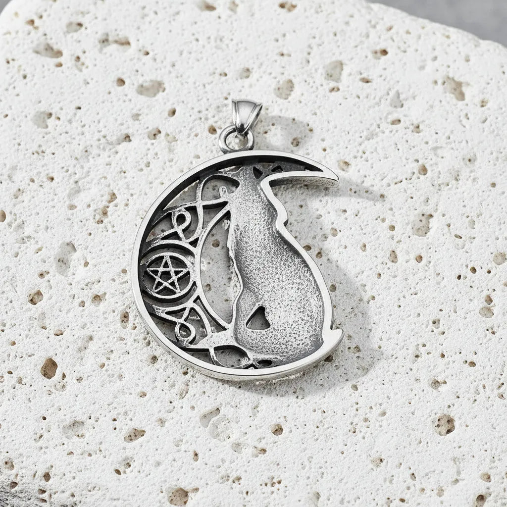 Silver pendant with a design of a deer and pentacle symbol held in a hand against a gray background