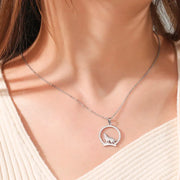 Silver wolf pendant necklace worn with a white top — spirit animal jewelry