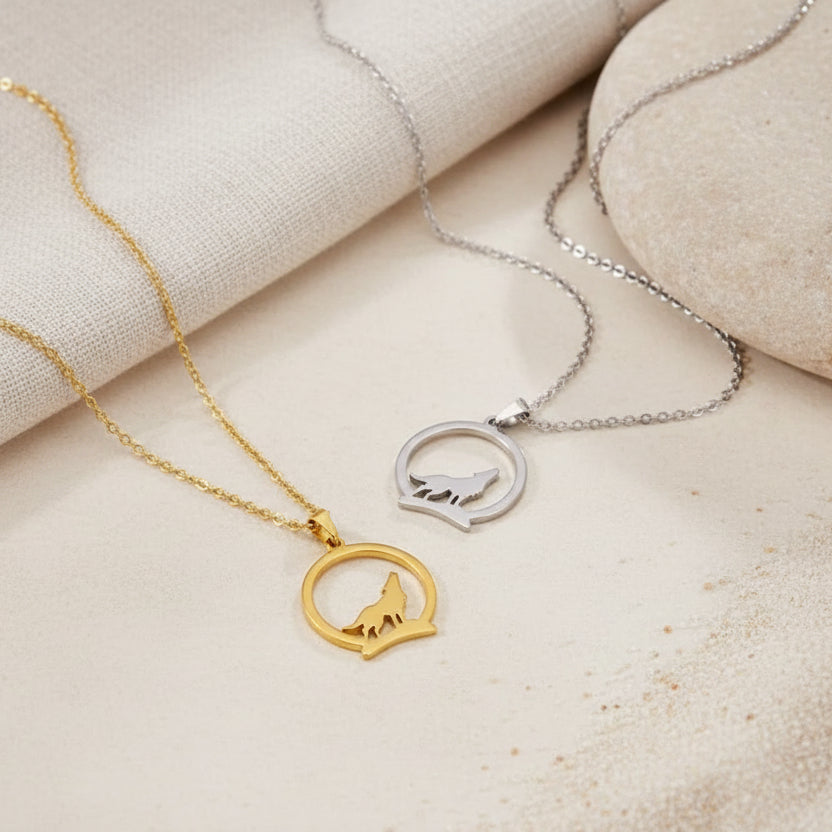 Two necklaces with wolf pendants on a dark background