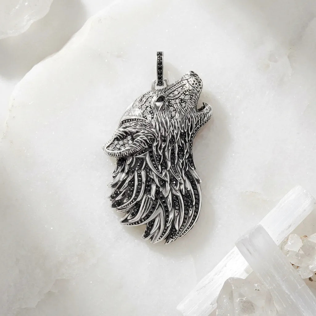Silver wolf head pendant on a white marble surface