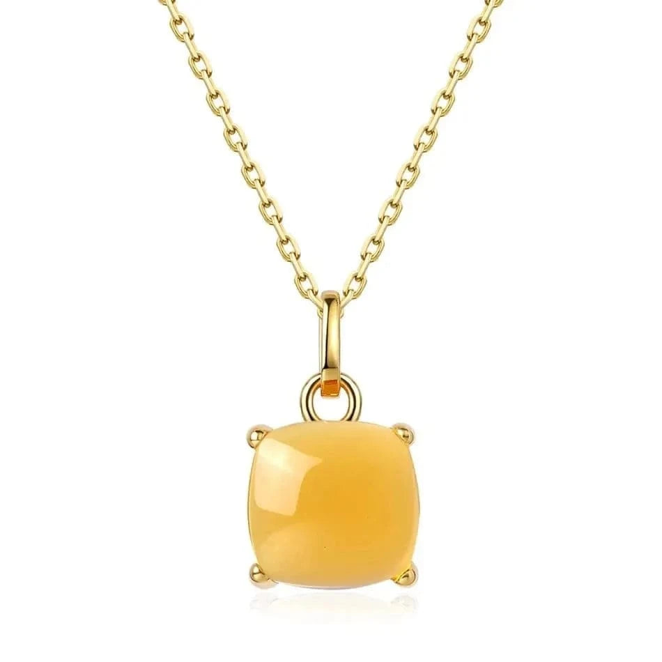 Gold necklace with a yellow gemstone pendant on a white background